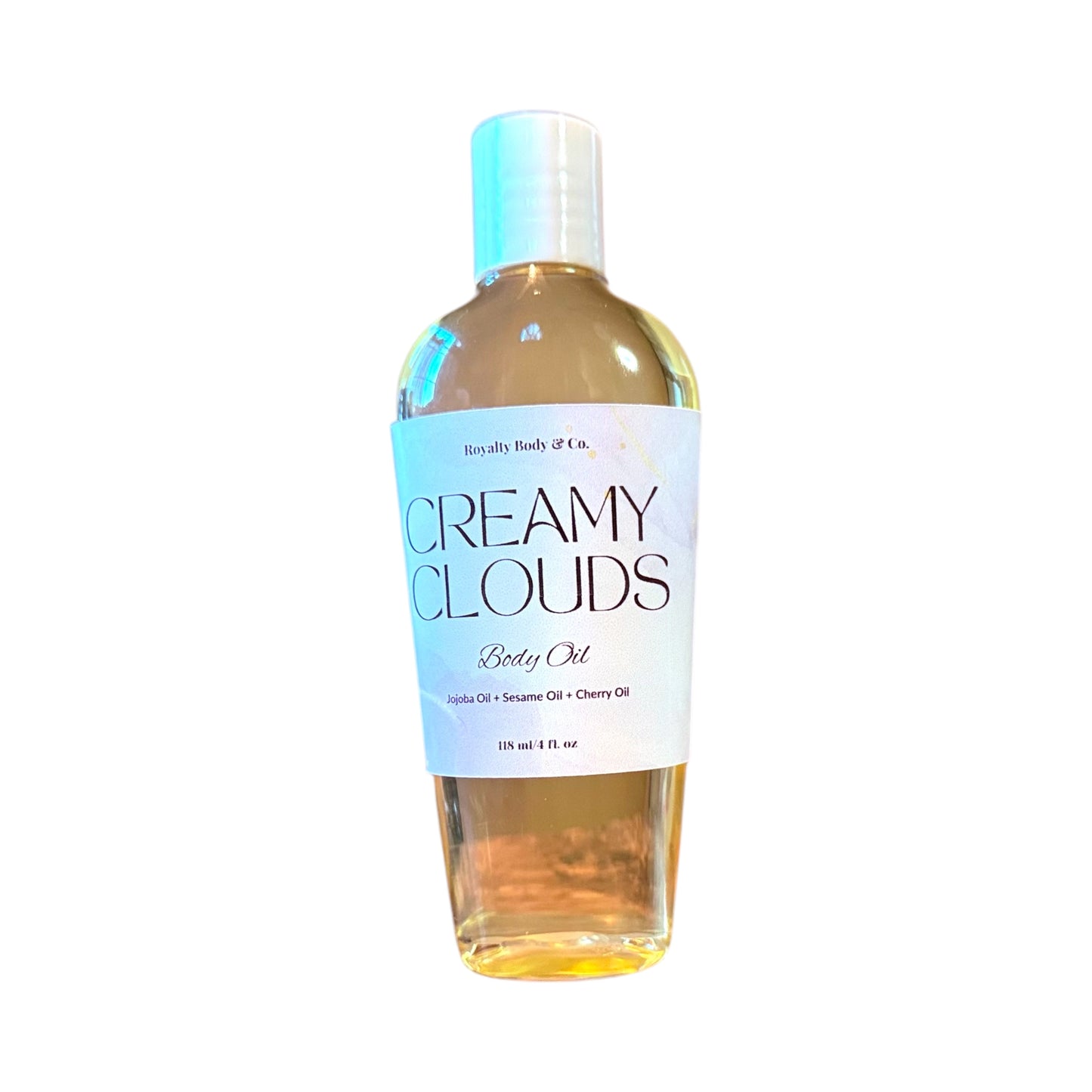 An 8 fl oz bottle of Creamy Clouds Body Oil by Royalty Body & Co. is displayed, providing intense hydration with a light yellow blend of jojoba, sesame, and cherry oils. The name is boldly printed on the white label for easy identification, and it offers a long-lasting fragrance.