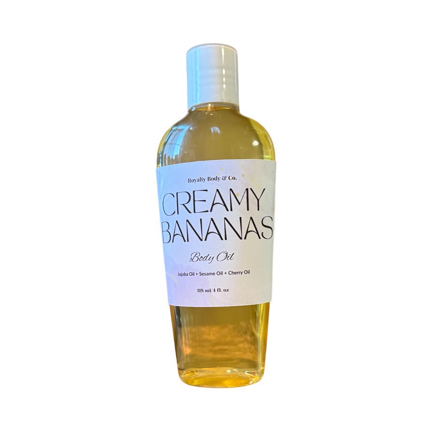 Rojally Body & Co.s Creamy Banana Body Oil provides intense hydration with jojoba, sesame, and cherry oils. The yellowish liquid comes in a clear bottle with a white cap and delivers a long-lasting fragrance for a deeply nourishing experience.