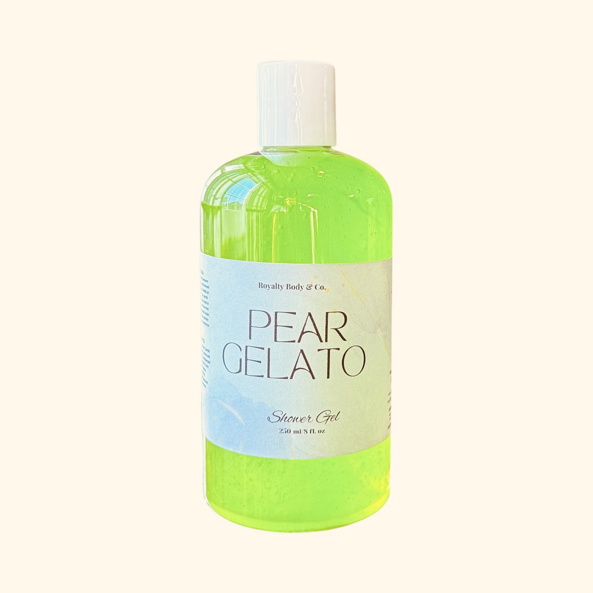 The Pear Gelato Shower Gel by Royally Body & Co. comes in a 250 ml bottle with a white cap and a textured label featuring blue and gold accents, designed to hydrate and nourish sensitive skin. The gel is bright green against a pale cream background.